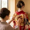 成人式の振袖を着せ付けるお母様の手元と後ろ姿の帯結び